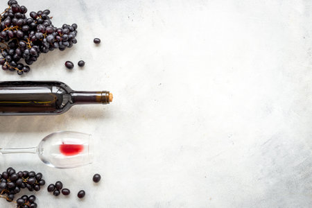 Bottle of red wine with bunch of grapes and wineglass.の写真素材