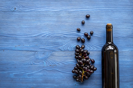 Red wine in the bottle with a bunch of grapes, top view.の写真素材