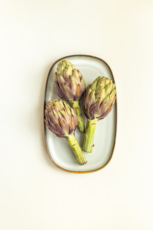 Healthy food - raw artichokes, green and purple. Vegetables background.の写真素材