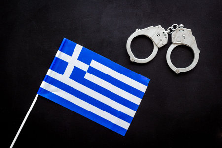 Metal handcuffs for criminals with Greece flag. Local criminal law and justice concept.の写真素材