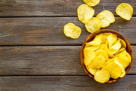 Wooden bowl of crispy potato chips, top view. Fast food and snack background.の写真素材