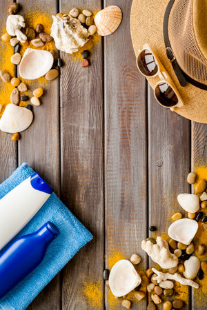 Beach accessories on wooden board. Male straw hat and sunscreen, top viewの写真素材