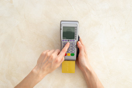 Female holding in hands bank terminal for contactless payment by credit cards. Banking and shopping concept.の写真素材