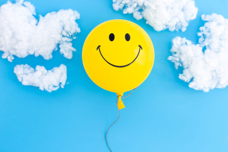 Happy smiling balloon in clouds. Optimistic positive mind concept.