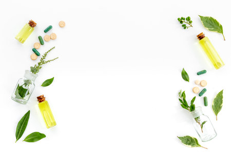 Chinese herbal medicine concept. Healing fresh herbs and essential oil in glass bottles.の写真素材