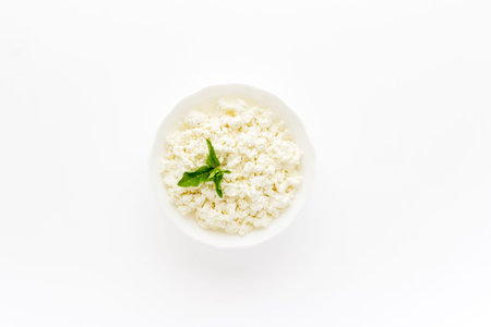 Farm cottage cheese in white bowl, top view. Healthy protein breakfast.