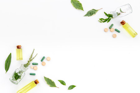 Alternative herbal medicine concept with healing herbs and essential oil in glass bottles.の写真素材