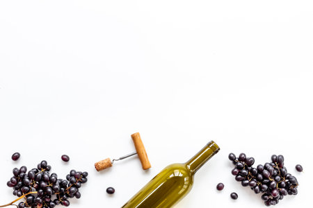 Open bottle of red wine with bunch of grapes and cork, top view.の写真素材