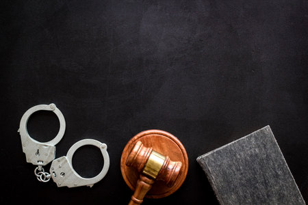 Police metal handcuffs with criminal code book and judges gavel. Law and justice concept.の写真素材