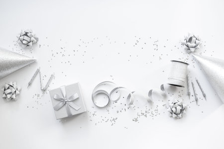 Party background in silver monochrome color. Gift box with party hats, top view.の写真素材
