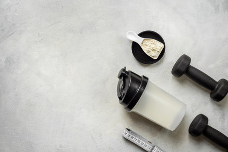 Protein shaker for sports nutrition. Whey protein powder in a scoop, top view