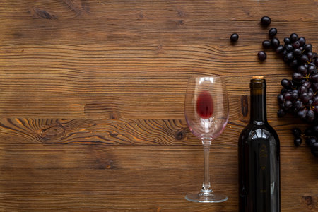Bottle of red wine with bunch of grapes and wineglass.の写真素材