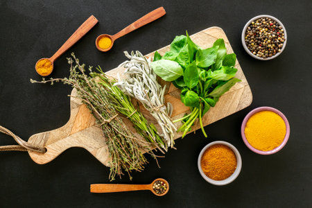 Fresh green herbs on wooden board and spices, top view. Cooking background.の写真素材