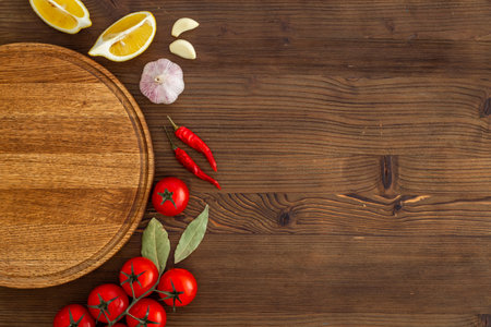 Wooden cutting board and vegetables with spices, top view. Cooking layout.の写真素材