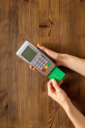 Female holding in hands bank terminal for contactless payment by credit cards. Banking and shopping concept.の写真素材