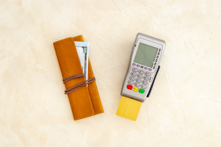 Choosing payment method concept. Bank payment terminal with credit cards and wallet, top view.