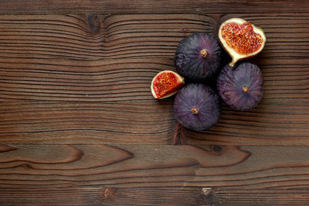Whole and cut fresh ripe figs on wooden table. Top viewの写真素材