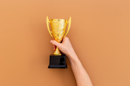 You are a champion. Hand holding award golden trophy cup.の写真素材