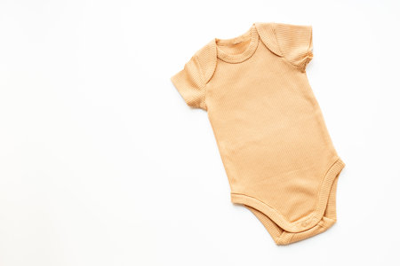 Cotton baby beige bodysuit on white background, top view.の写真素材