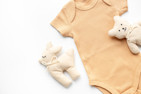 Cotton nude baby bodysuit and eco friendly toys on white background, top view. Zero waste lifestyle.の写真素材