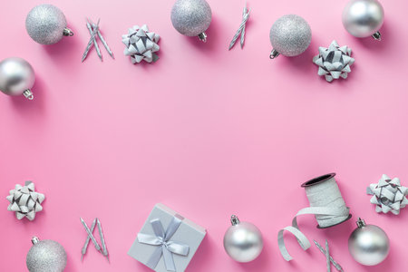 Frame of silver Christmas and New Year decorations on pink background. Top view.の写真素材