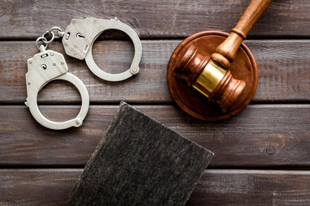 Metal handcuffs with judges gavel and criminal code book. Criminal law and justice concept.の写真素材