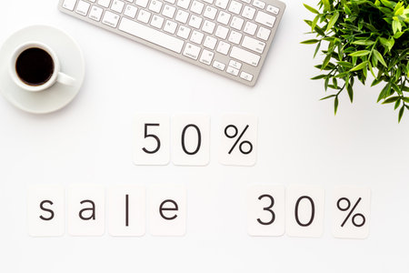 Sales concept. Online shopping - white table with computer and discount sing, top view.の写真素材