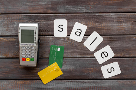 Sales sing with POS payment terminal and credit cards, top view. Online shopping concept.