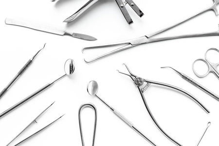 Surgical scissors and forceps. Medical metal hand tools and equipment on white, top view.