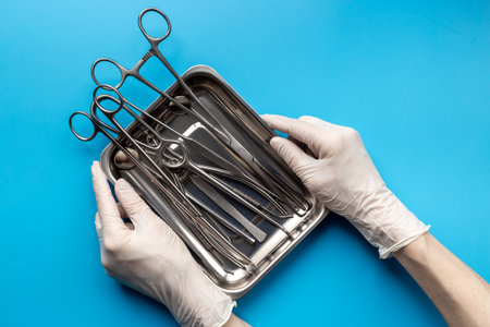 Flat lay of surgical stainless metal hand tools in tray. Professional medical equipment and...
