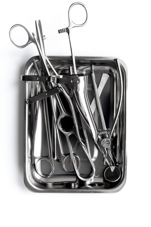 Professional medical equipment - surgery stainless metal instruments in tray on white background....