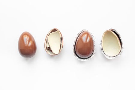 Chocolate background. Broken and whole chocolate eggs, top view.