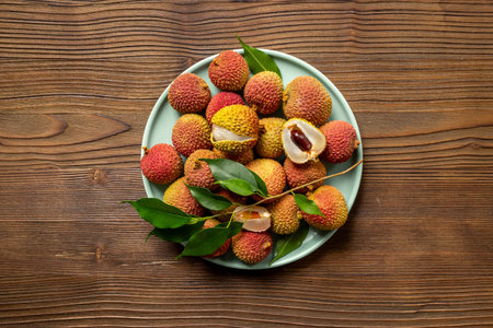 Lychee with green leaf on the plate, top view. Tropical fruits background.の写真素材