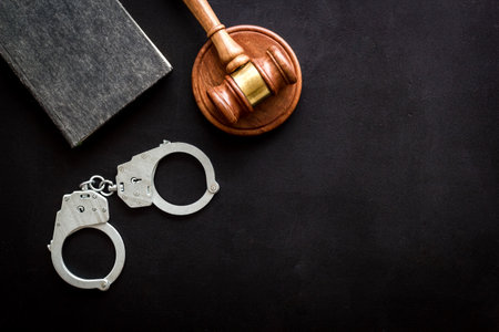 Judges gavel and police metal handcuffs, top view. Criminal offense and detention concept.の写真素材