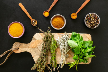 Fresh green herbs on wooden board and spices, top view. Cooking background.の写真素材