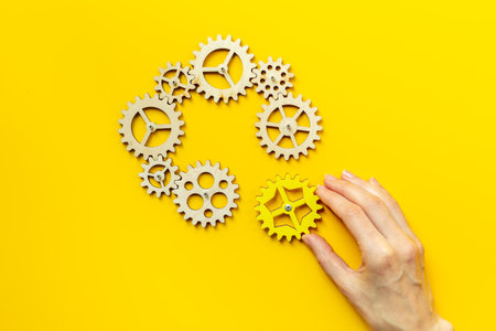 Hand is putting together cogwheels. Business automation and corporate work concept.の写真素材