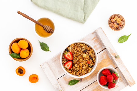 Bowl of cereal granola with strawberry and honey for breakfast, top viewの写真素材