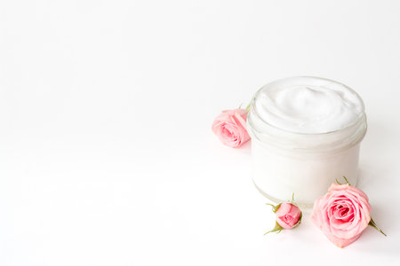 Closeup of pink roses and skin care cream with flowers essential oil.の写真素材