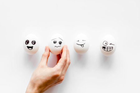Sadness emotion concept. Hand holds egg with facial expressions. Communication and comments on...