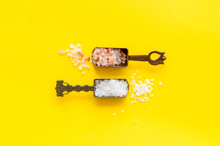 White and pink salt - coarse and finely - in metal spoons. Salt for spa, salt baths or cooking.