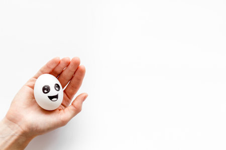 Positive emotion concept. Hand holds egg with facial expressions. Communication and comments on social networks.の写真素材