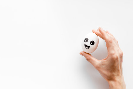 Positive emotion concept. Hand holds egg with facial expressions. Communication and comments on social networks.の写真素材