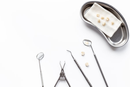 Dental steel instruments for dental prosthetics and oral treatment on a white background. Dentist desk top view.の写真素材
