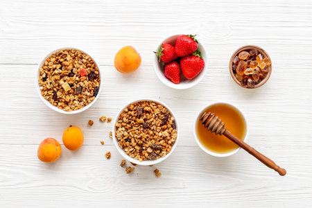 Flat lay of oatmeal granola and ingredients served on white table. Healthy breakfast.の写真素材