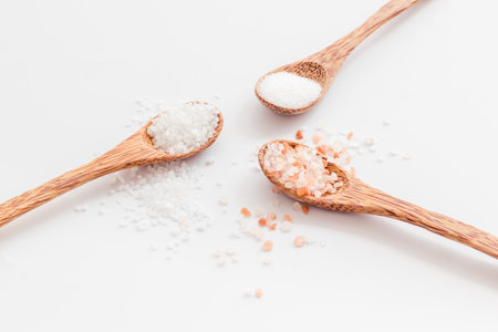 Different kind of sea salt in wooden spoon, close up. Salt for spa, salt baths or cooking.の写真素材