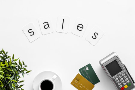 Sales sing on white background with POS payment terminal and credit cards, top view. Online shopping...