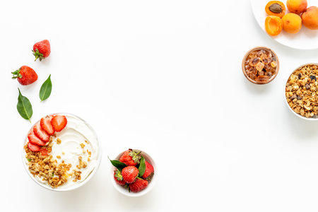 Flat lay composition with yogurt and muesli in bowl served with ingredients. Top view.の写真素材