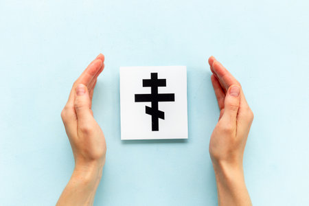 Hands holding Christianity cross symbol. World religious concept.の写真素材
