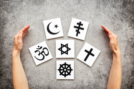 World religious concept. Hands holding Christianity cross, Islam crescent, Buddhism dharma wheel, Hinduism aum, Judaism David star symbols, top view.の写真素材