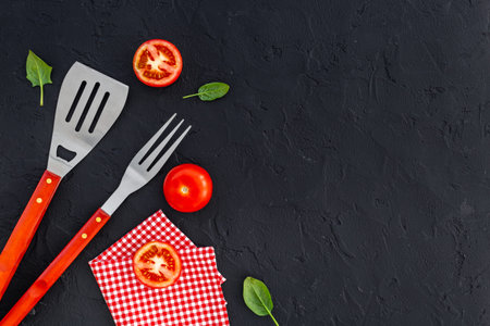Stainless steel utensils and red picnic napkin, top view. Barbecue utensils.の写真素材
